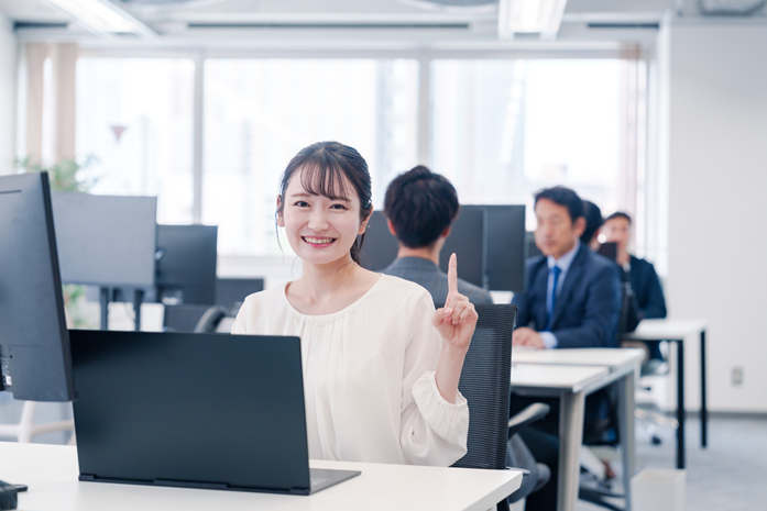 オフィスで人差し指を立てる若い女性