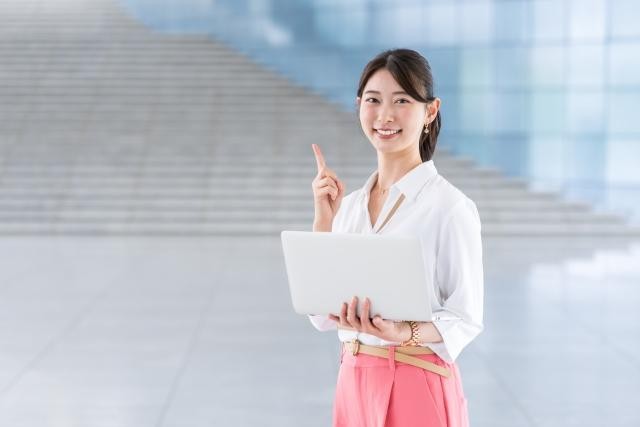 人差し指を立てて案内する笑顔の女性