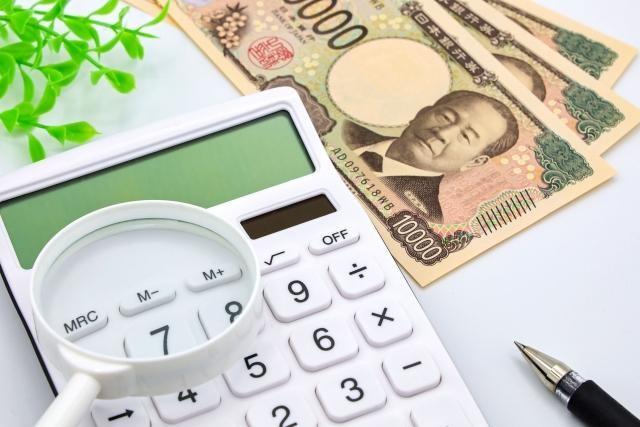 コストを計算するイメージ（電卓・虫眼鏡・一万円札・ペン）