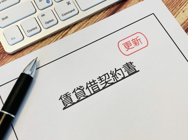 賃貸借契約書（更新）の書類、ペン、キーボード