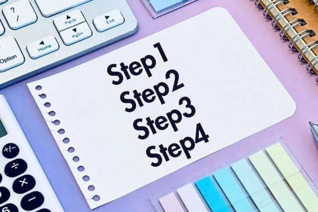 ステップ1から4まで書かれた用紙とパソコン・文房具類